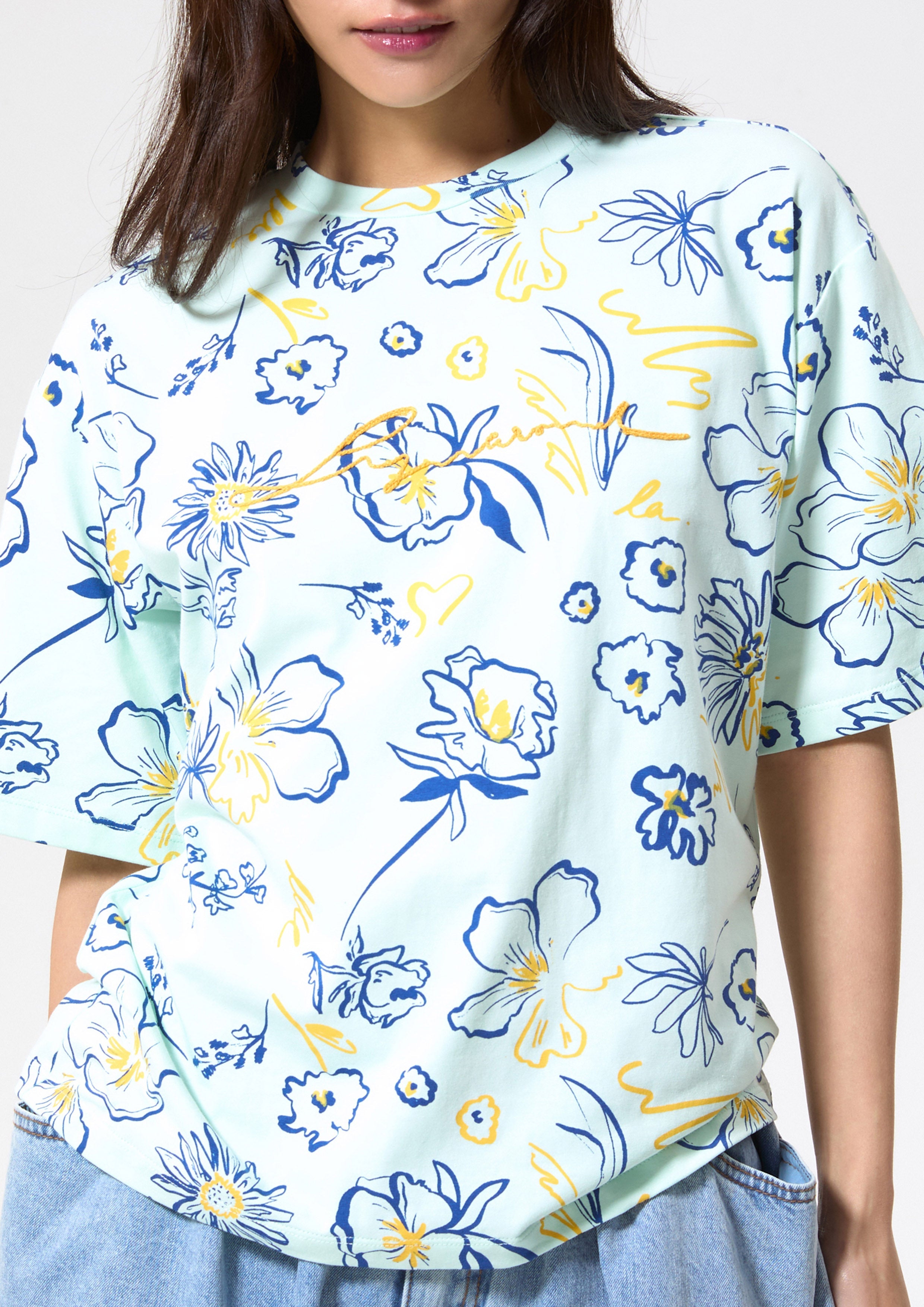 เสื้อยืดแขนสั้นพิมพ์ลายดอกไม้ คอลเลกชัน Blossom Elegance